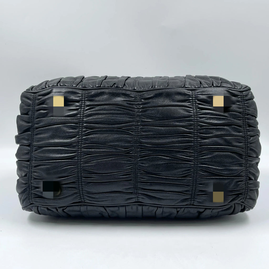Black pleated leather luxury designer handbag base with protective metal feet. Classic retro style elegant tote.
