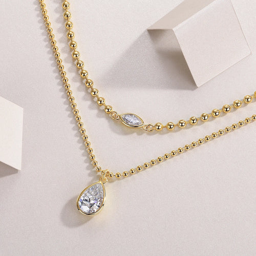 Gold-tone layered necklace with three moissanite teardrop charms on linked ball chains