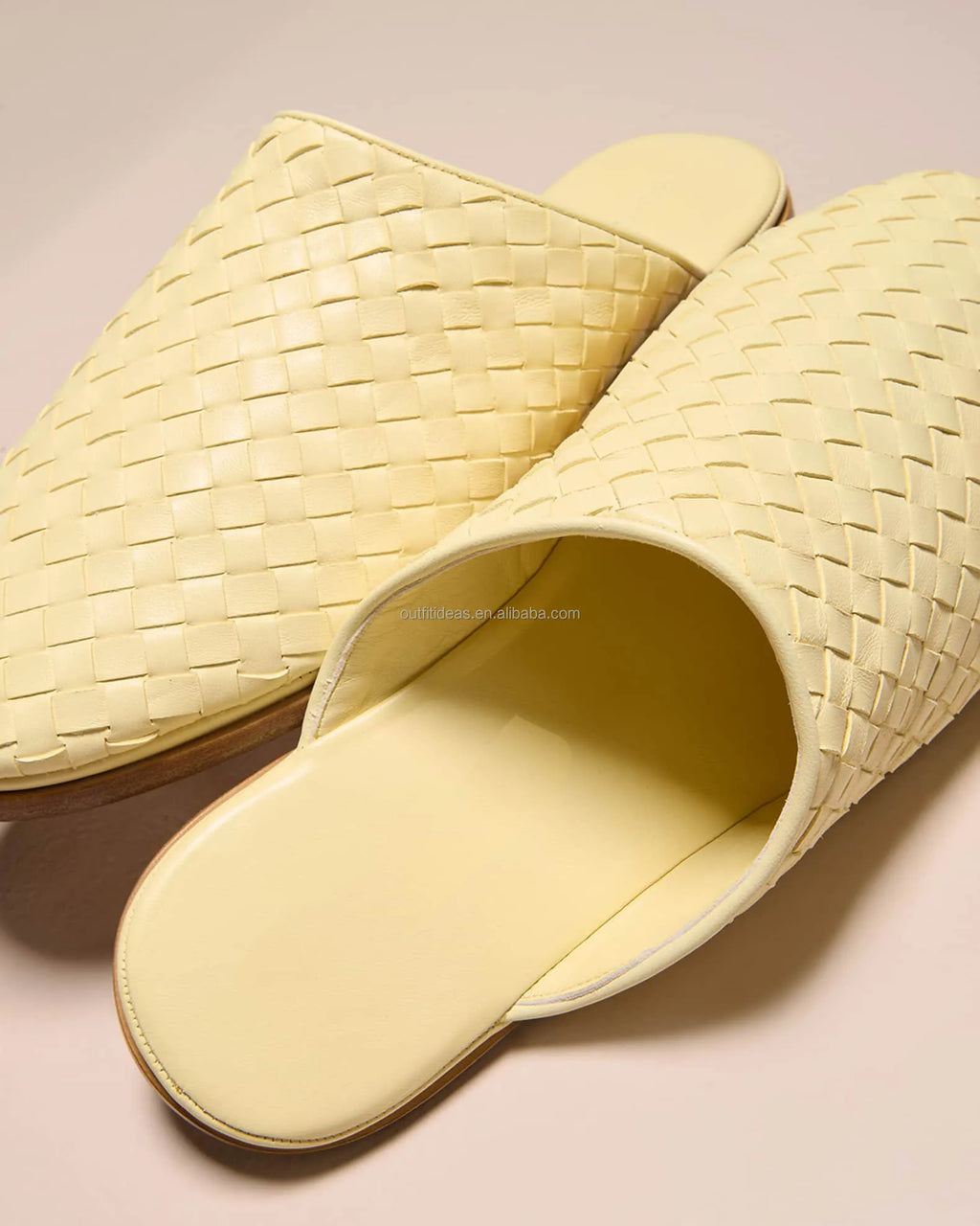 Luxury pale yellow woven leather mule loafers with flat stacked soles. Slip-on style with intricate basket-weave design.