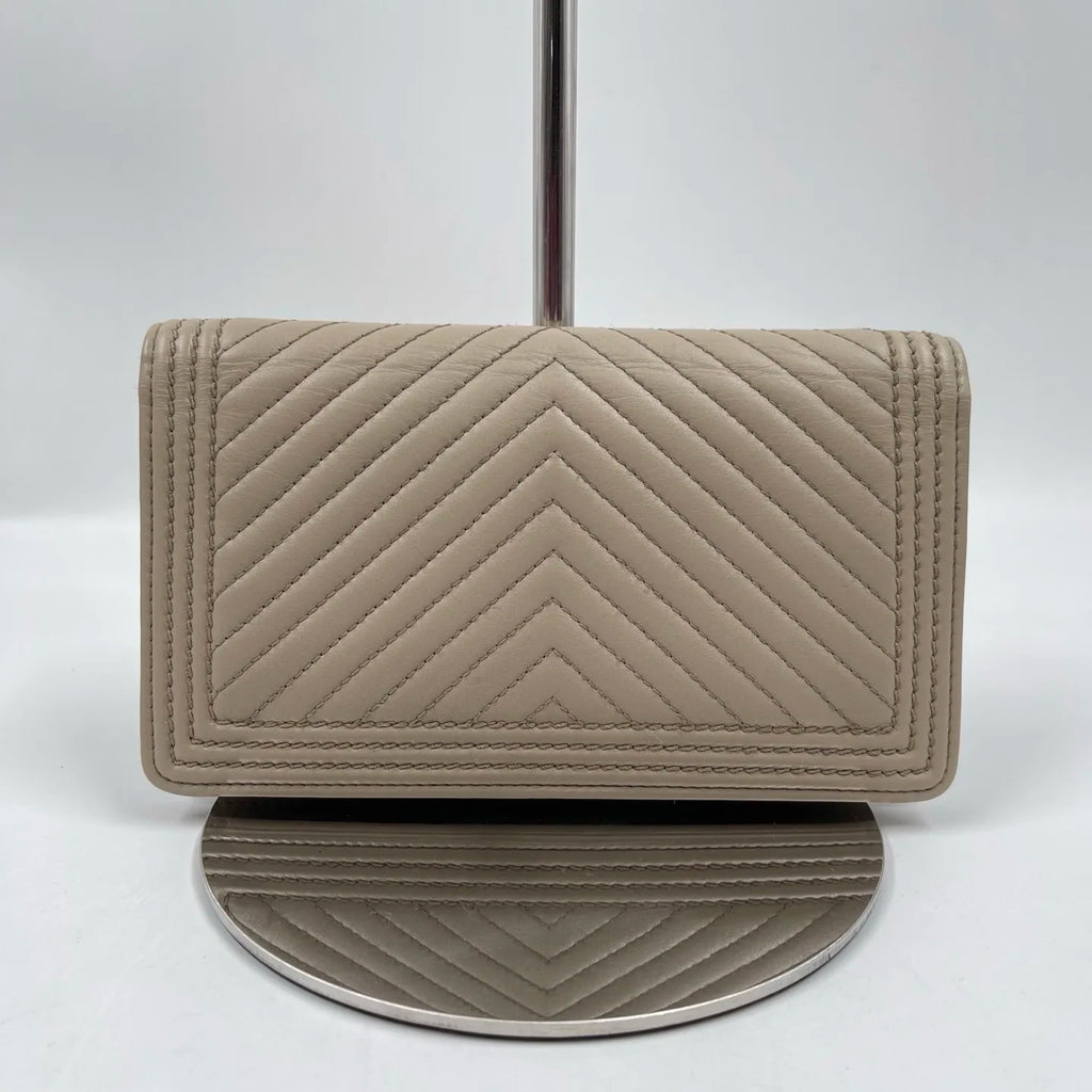 Elegant pre-owned designer tan wallet in genuine leather with chevron quilted stitching. Luxury fashion accessory.