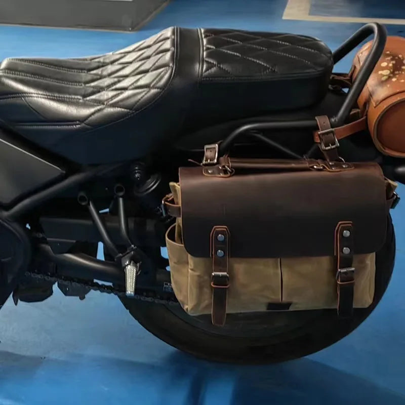 Retro motorcycle saddlebag in waterproof oil wax canvas and brown crazy horse leather with buckle straps on a bike.