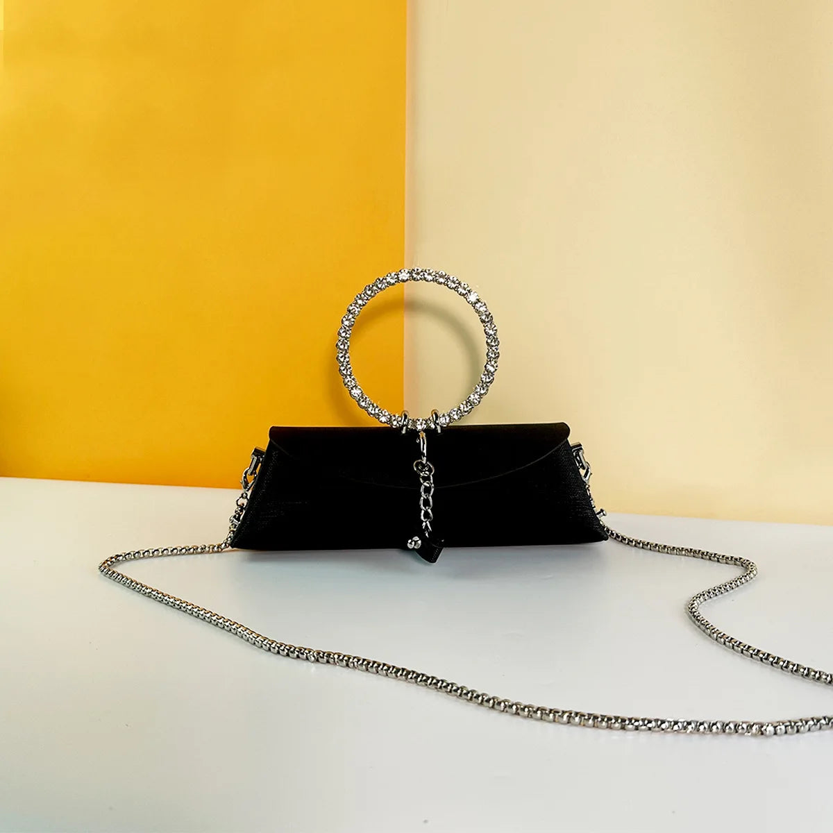 Black luxury evening clutch with rhinestone ring handle, detachable silver chain strap, and elegant wedding trunk style.