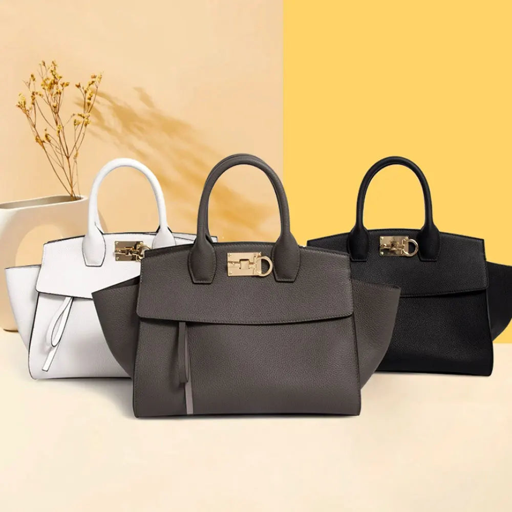 Luxury genuine leather tote bags in white, grey, and black with gold hardware and structured handbag design.