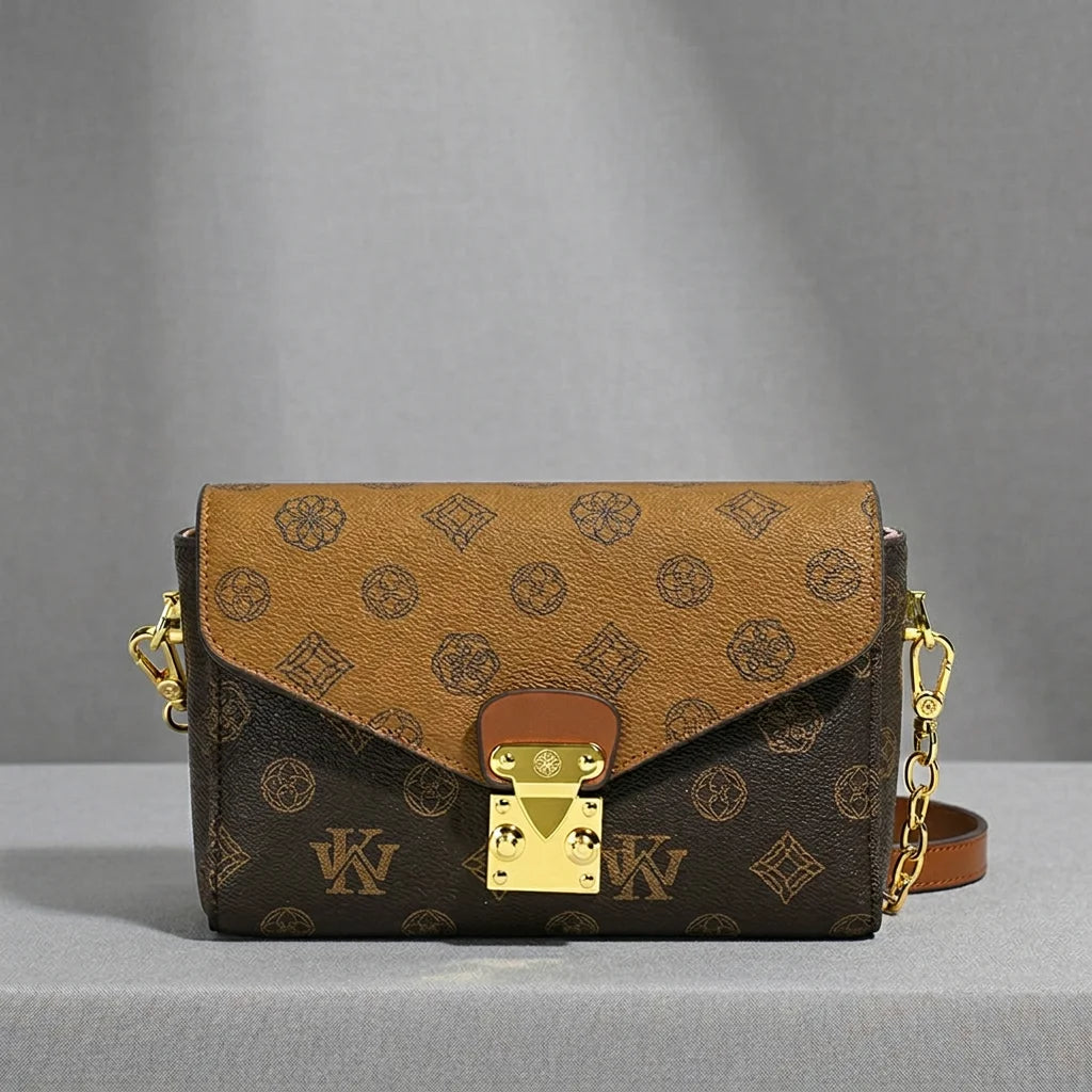 Two-tone brown monogram leather envelope crossbody bag with gold hardware and chain strap, luxury trunk style purse.