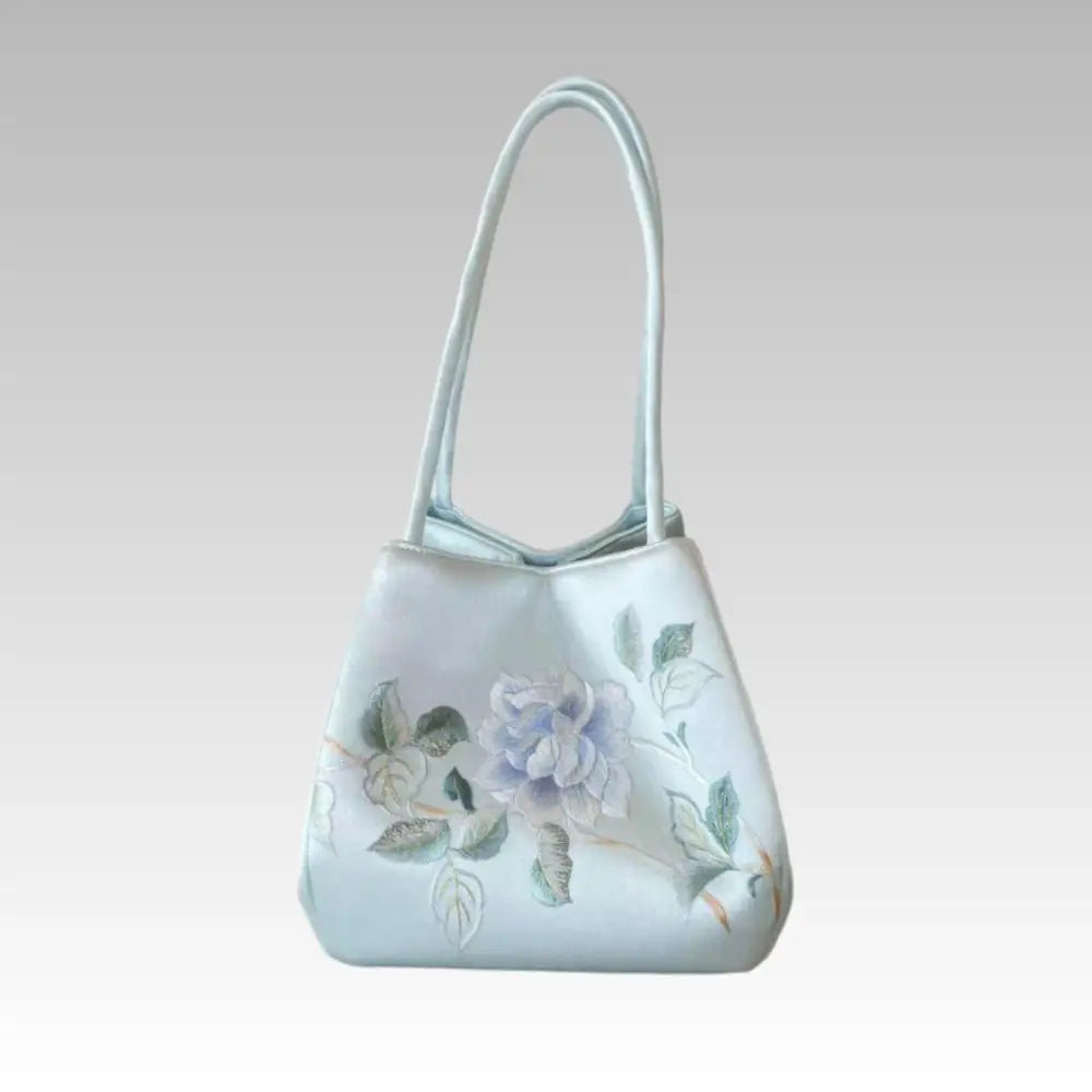 Handmade light blue silk handbag with intricate Suzhou embroidery featuring a delicate floral rose design.