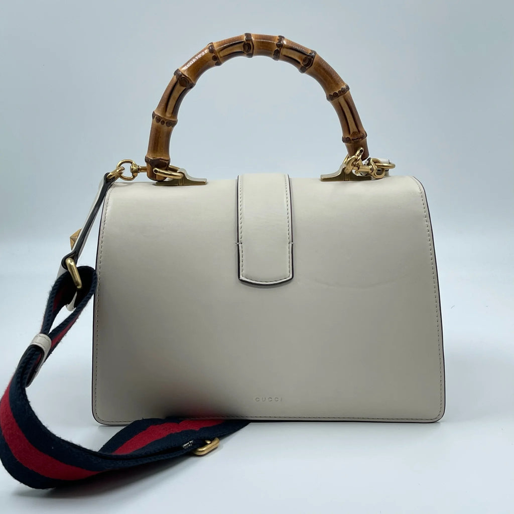 White genuine leather Gucci designer handbag with bamboo top handle and colorful striped detachable shoulder strap.