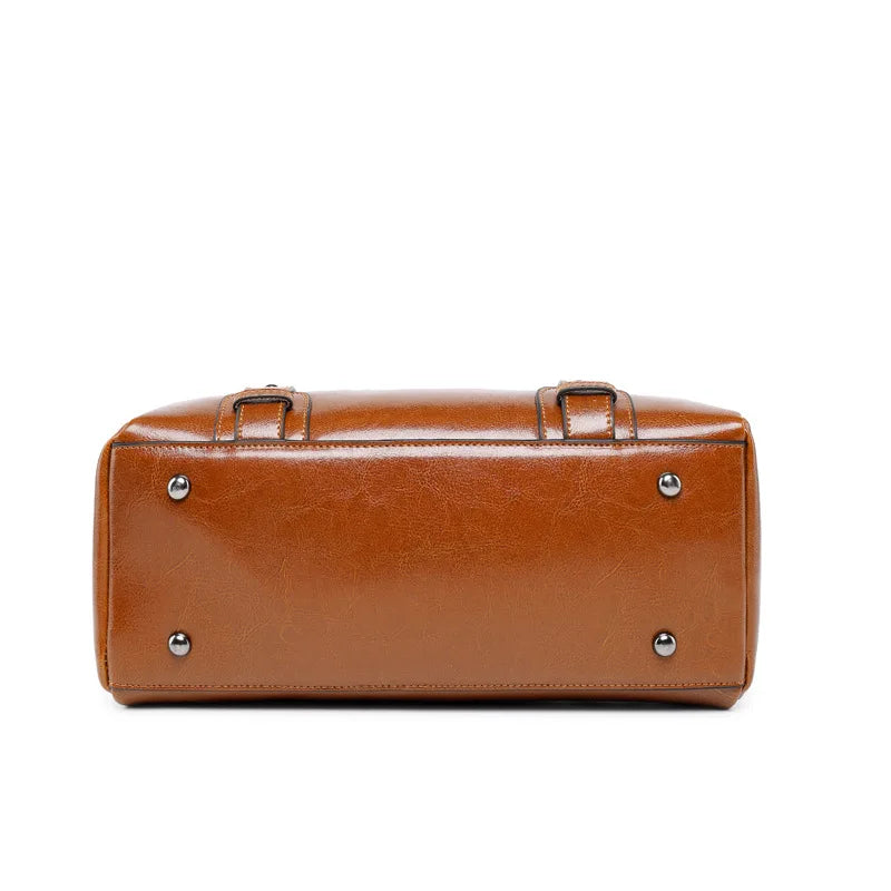 Brown cow split leather handbag base with protective metal feet, showcasing designer tote satchel structural details.