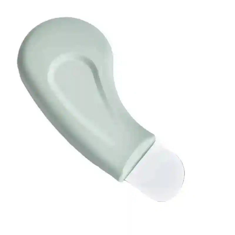 Pale green, curved, handheld pore cleansing tool with a flat, rounded metallic spatula tip on a white background.