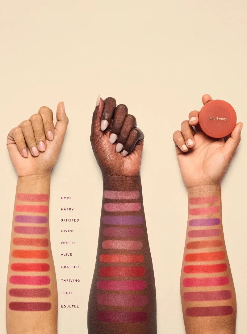 Rare Beauty soft powder blush swatches in diverse skin tones, showing matte mud-like textures in ten vibrant shades.