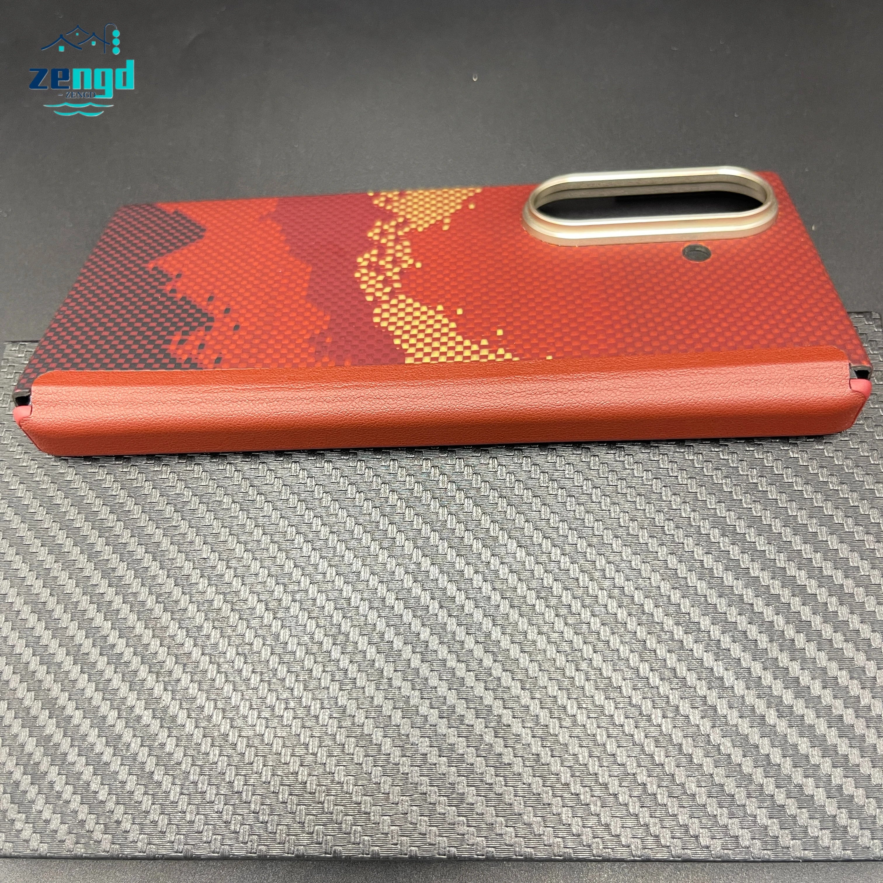 Red and black patterned foldable phone case with a leather spine and metallic camera bezel for protection.