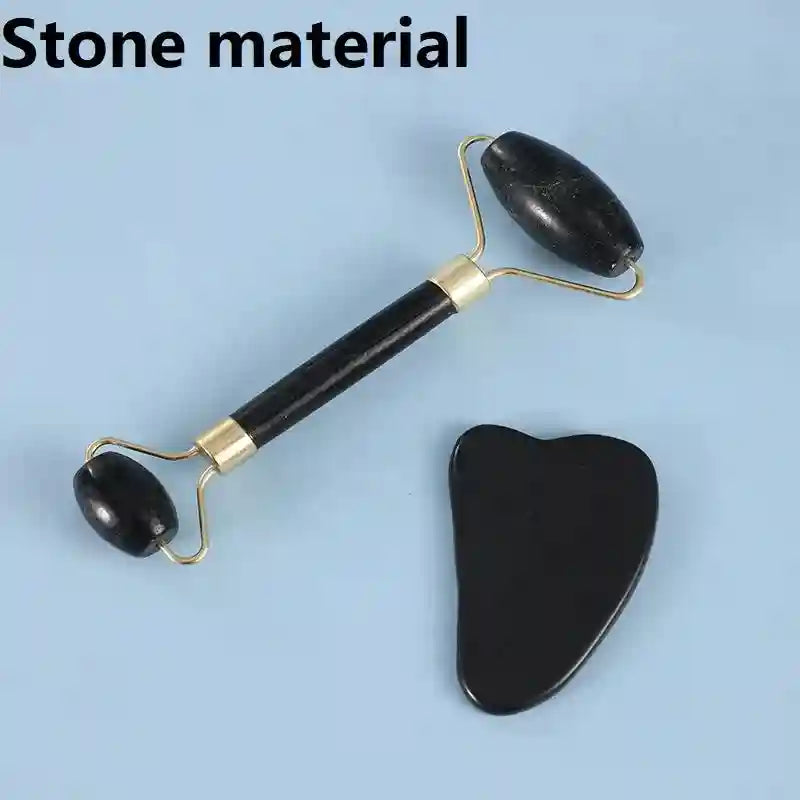 Set of black stone facial massage tools: a dual-ended roller with gold hardware and a heart-shaped gua sha scraper.