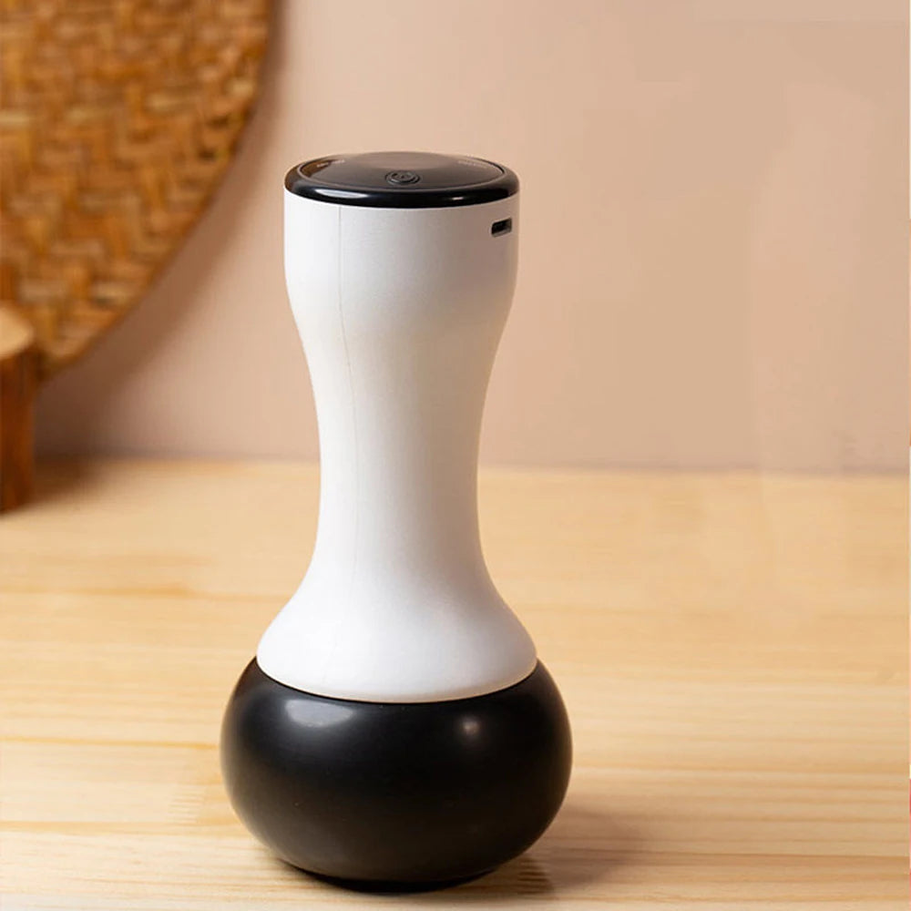 Electric Bian stone gua sha massager with a sleek white hourglass-shaped handle and a rounded black base on a table.