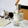 SantaleX No.33 Santal EDP: Unisex woody amber perfume in a clear glass bottle with a minimalist label. Warm spicy scent.