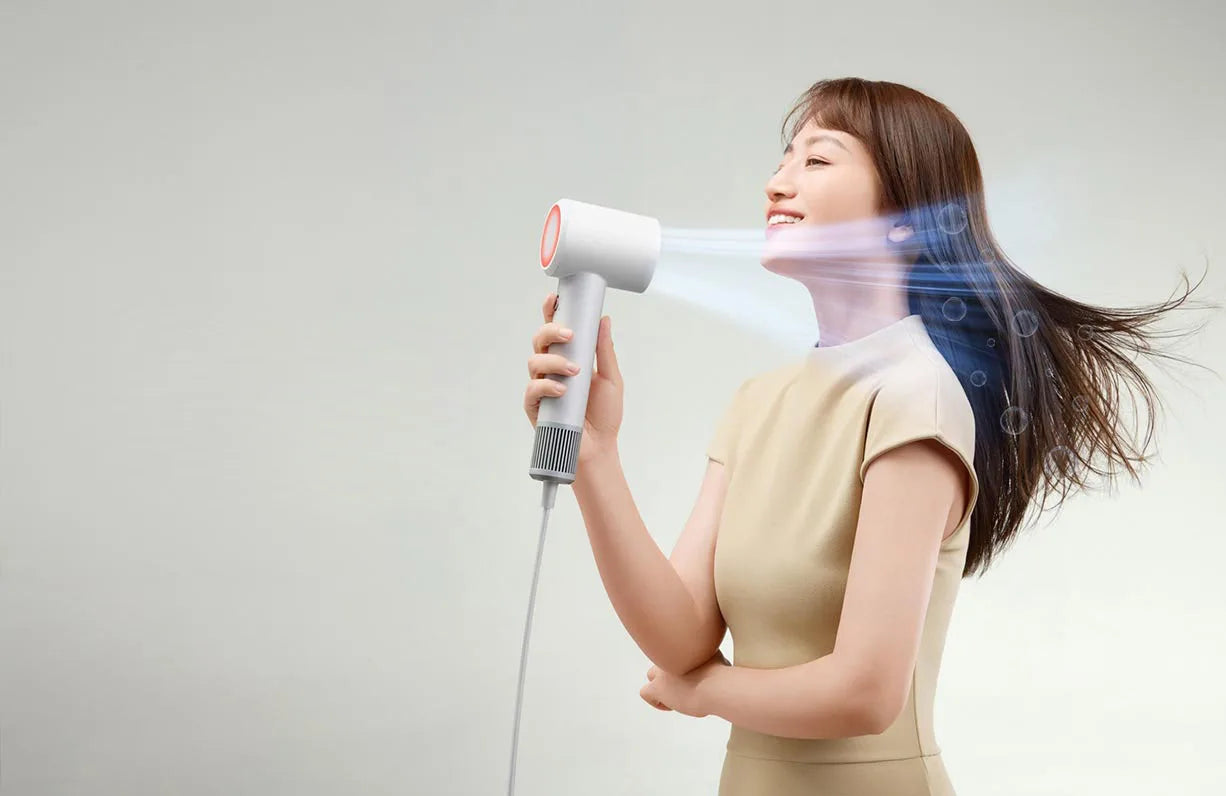 Woman using white Mijia H501 SE high-speed negative ion hair dryer for professional salon-quality drying at home.
