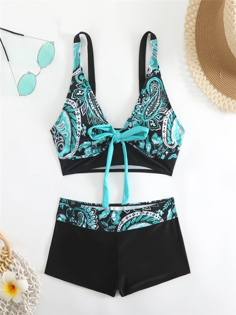 Tidesmit high-waisted bikini with teal and black paisley print, front tie detail, and smooth athletic fabric.