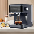 Matte black espresso machine with digital touch panel, portafilter, and steam wand brewing two shots of coffee.