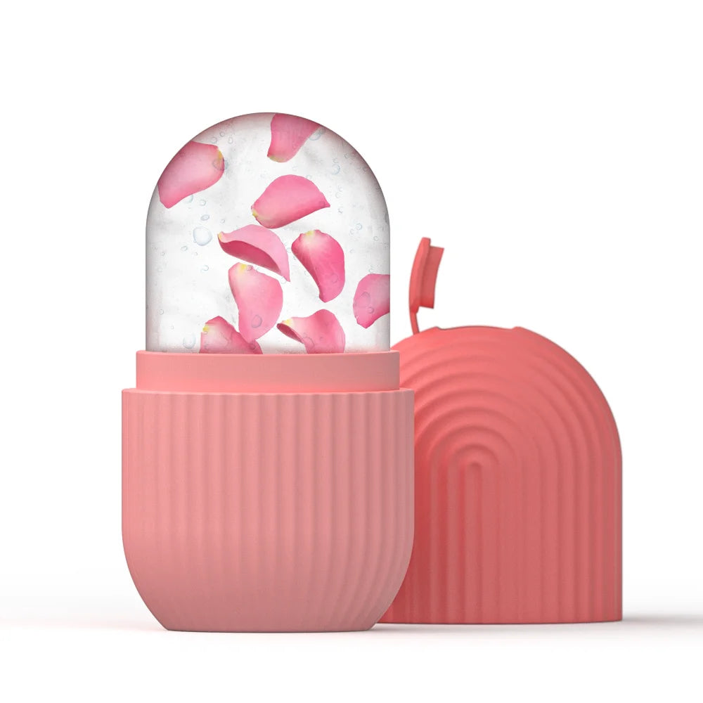 Pink silicone face ice roller mold containing clear ice with pink flower petals, next to its ribbed matching lid.