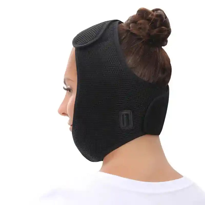 Side view of a person wearing a black, mesh-fabric electric face heating wrap secured with velcro straps.
