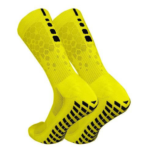 Pair of neon yellow Tidesmit athletic crew socks featuring black non-slip rubber grips on the soles and heels.