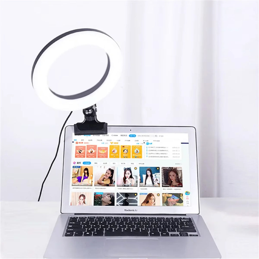 Circular LED ring light with a black clip, attached to a laptop screen for video conferencing illumination.