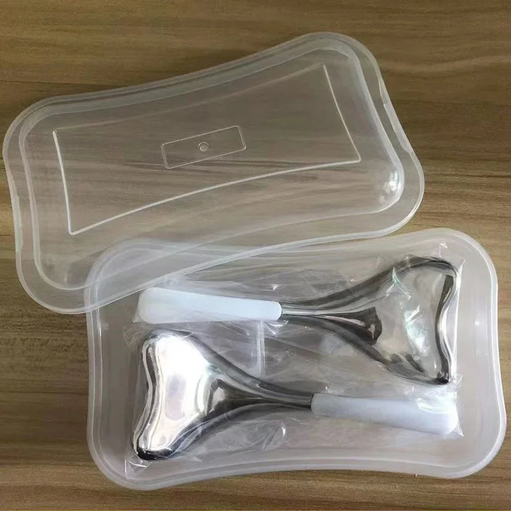 Two silver, ergonomic cryo facial massage tools with white handles, resting inside an open clear plastic storage case.