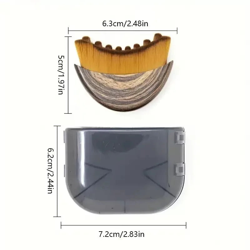 Crescent-shaped face brush with wood-grain handle and brown bristles, shown with its gray protective travel case.