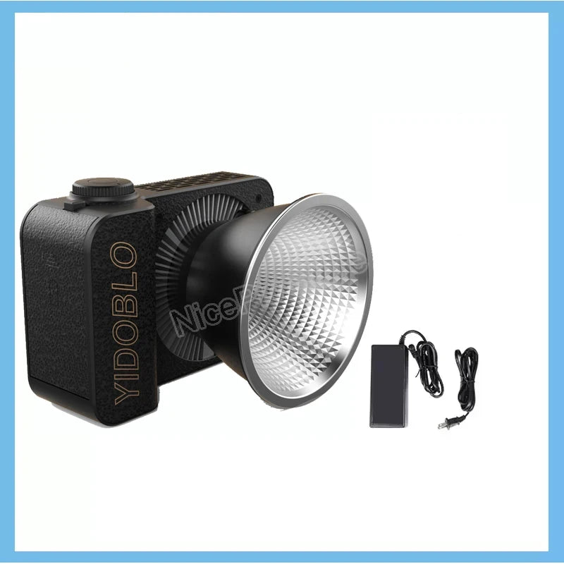Black LED COB video light with a textured rectangular housing, silver faceted reflector bowl, and power adapter.