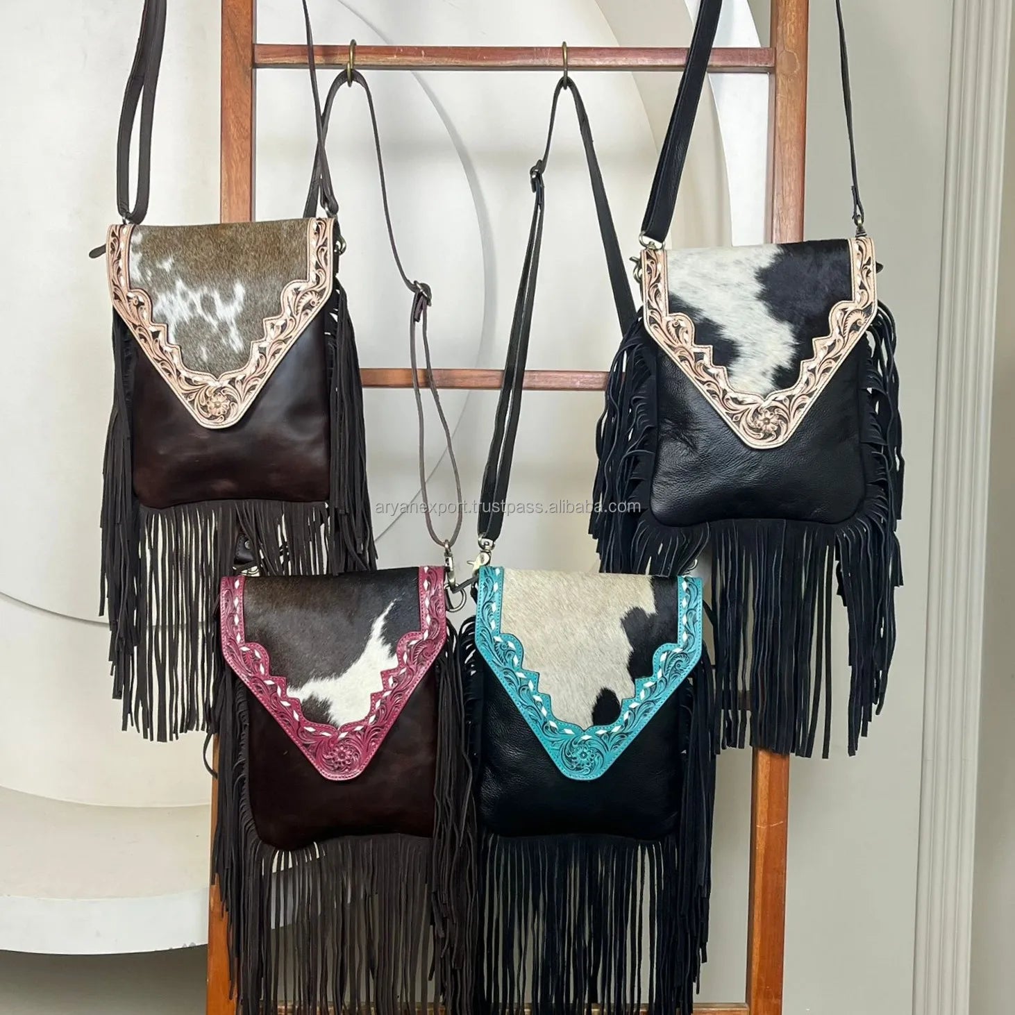 Designer fringe crossbody bags in tooled genuine leather with cowhide flaps in black, brown, turquoise, and pink.