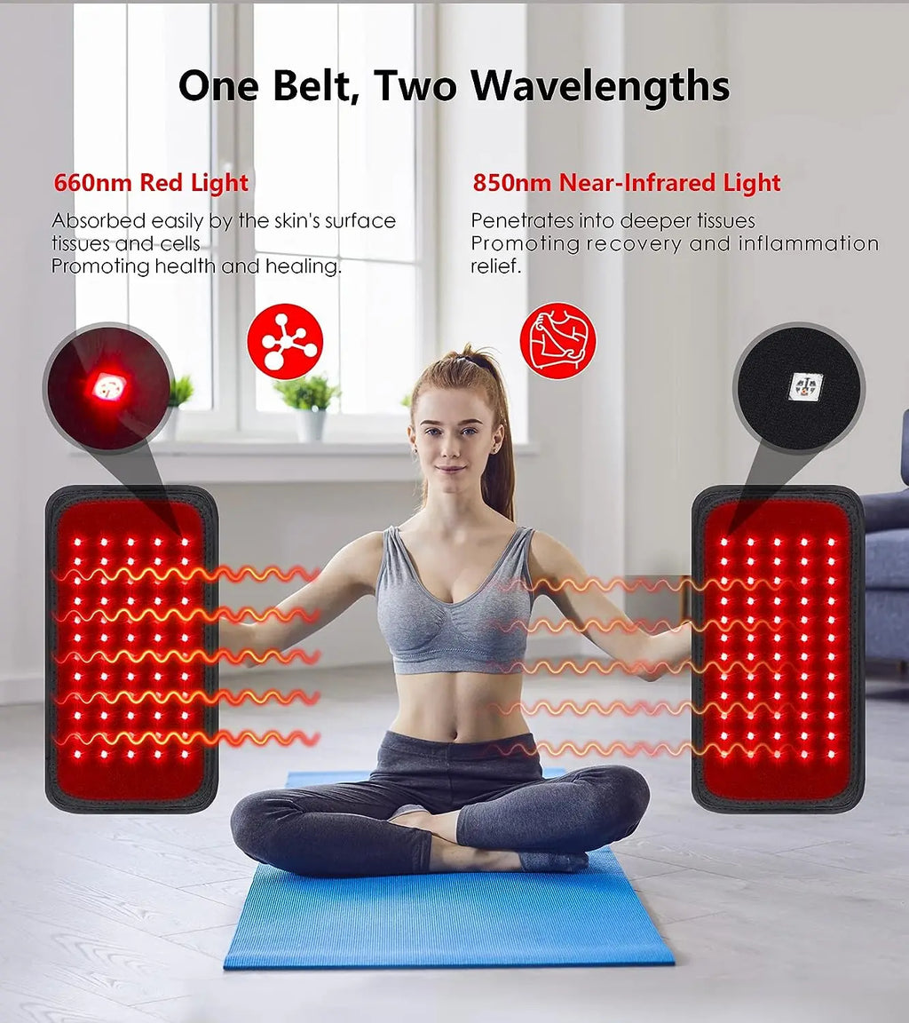 A person sitting on a blue yoga mat holding two rectangular red and infrared LED light therapy belts for pain relief.