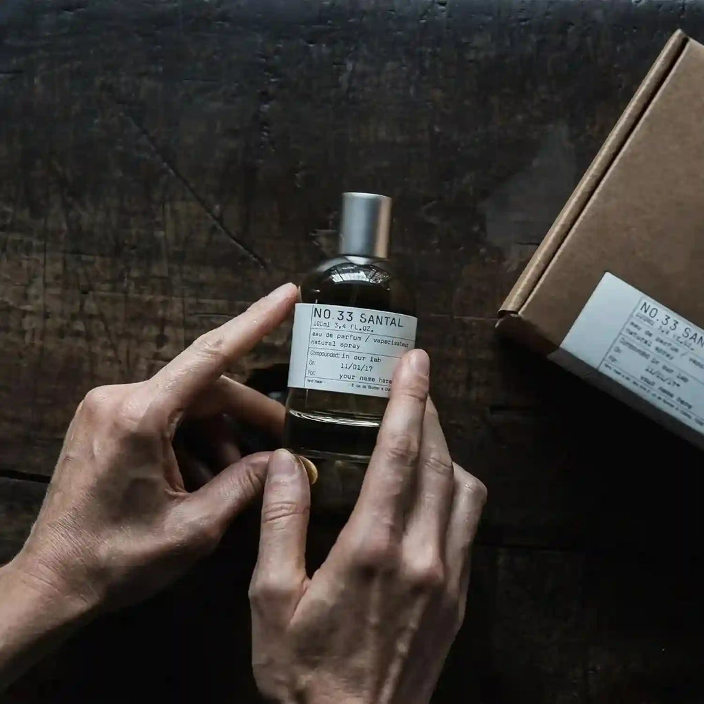 SantalX No.33 Santal unisex Eau de Parfum. Woody amber spicy scent in a sleek cylindrical glass bottle with label.