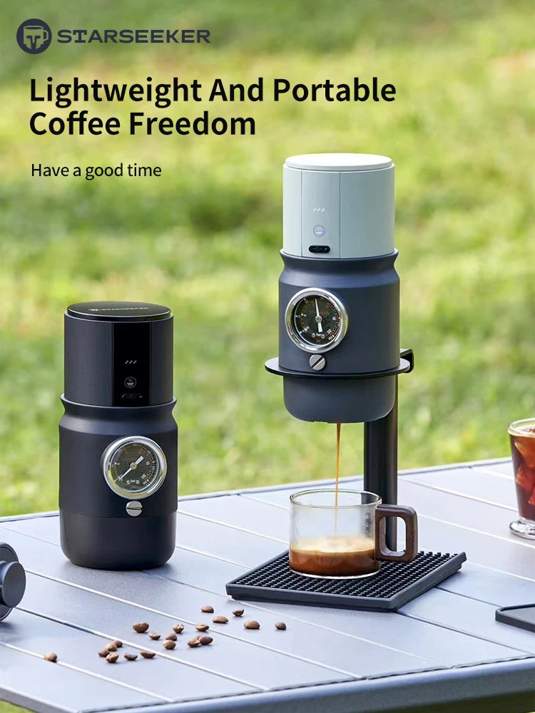 Starseeker portable matte black coffee maker with pressure gauge brewing espresso into a glass cup on outdoor table.
