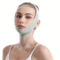 A woman wears a pale green, adjustable elastic face-slimming strap secured around her chin and over her head.