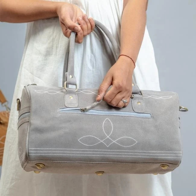Grey handmade genuine leather duffel trunk with elegant white boot stitch embroidery for stylish travel getaways.