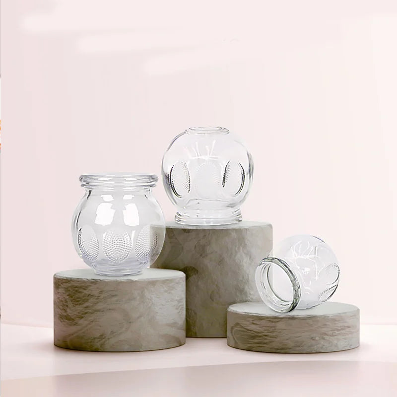 Extra thick glass cupping set for fire therapy, featuring textured grips on clear bowls displayed on stone pedestals.