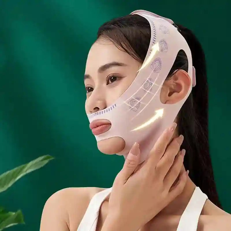 A person wears a light pink, V-line facial slimming bandage with patterned detailing over their chin and jaw.
