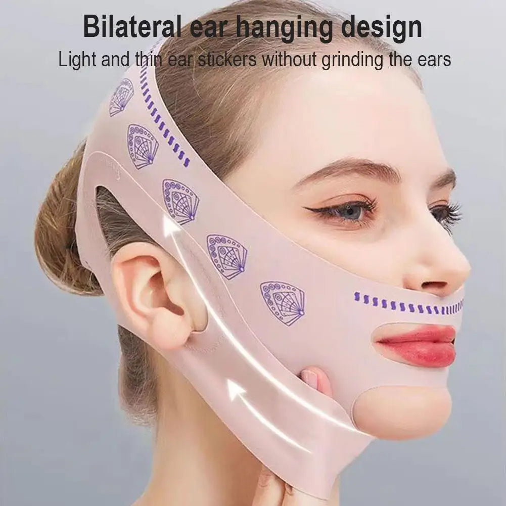 A light pink face-slimming strap with purple fan patterns, worn around the chin and ears for a V-line facial lift.