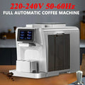Silver fully automatic coffee machine with touchscreen display and transparent water tank on a wooden kitchen counter.