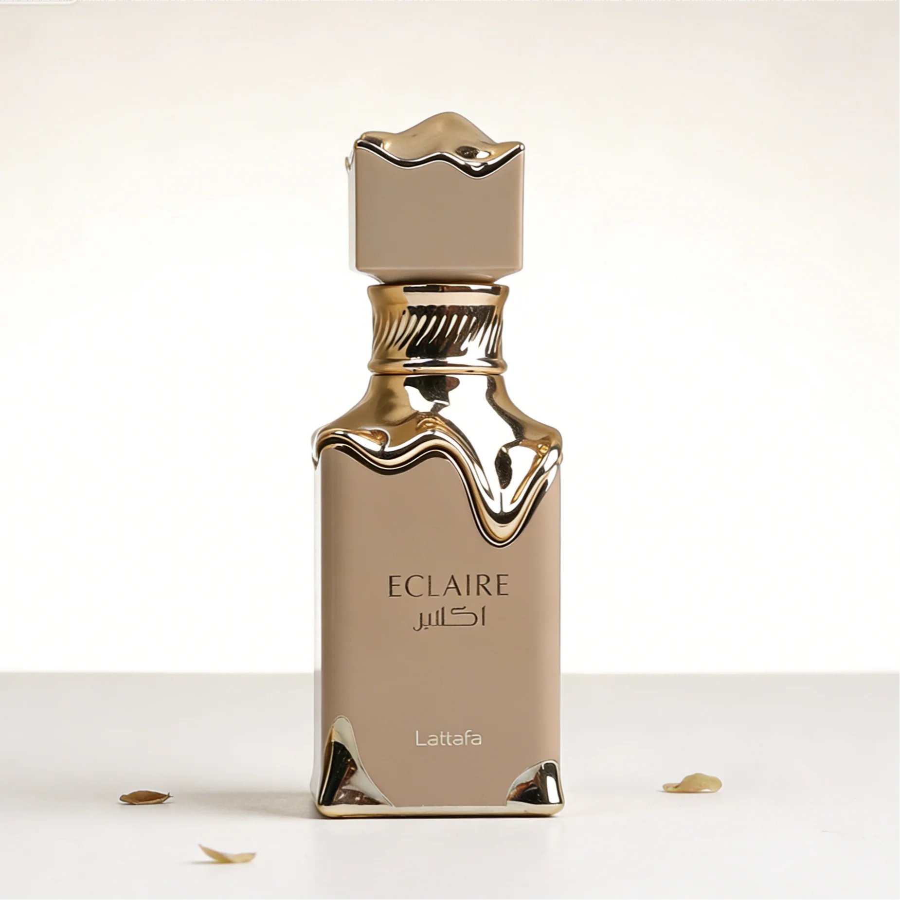 Lattafa Eclaire perfume bottle in beige with gold drip design and a sleek, modern luxury aesthetic on white surface.