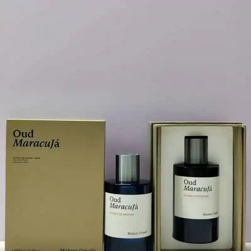 Oud Maracujá perfume, dark blue bottle and matching gift box with white labels and silver caps.