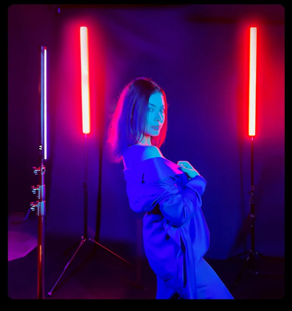 LED light stick on a tripod stand, emitting vibrant red and blue illumination for studio portrait photography.