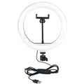 White circular ring light with a center phone mount, adjustable swivel head, and USB power cord with control buttons.