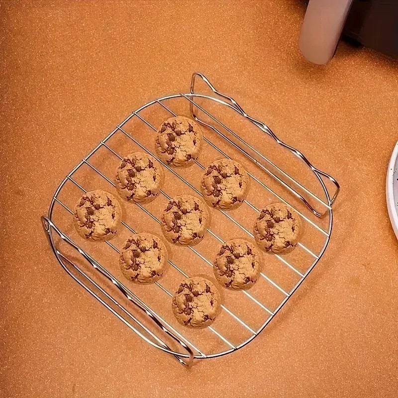 Square air fryer grilling rack holding six cookie-like meatballs for even cooking