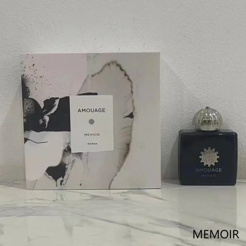 Amouage Memoir Woman Eau de Parfum: dark blue square bottle with silver cap and luxury gift box. Elegant fragrance.