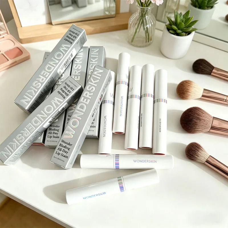 Wonderskin long-lasting waterproof peel-off lip stain tubes and silver packaging on a white makeup table.