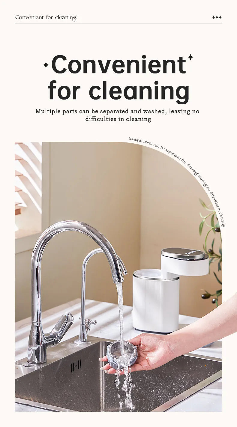 Hand washing a detachable white plastic filter part from a compact coffee maker under a kitchen faucet.