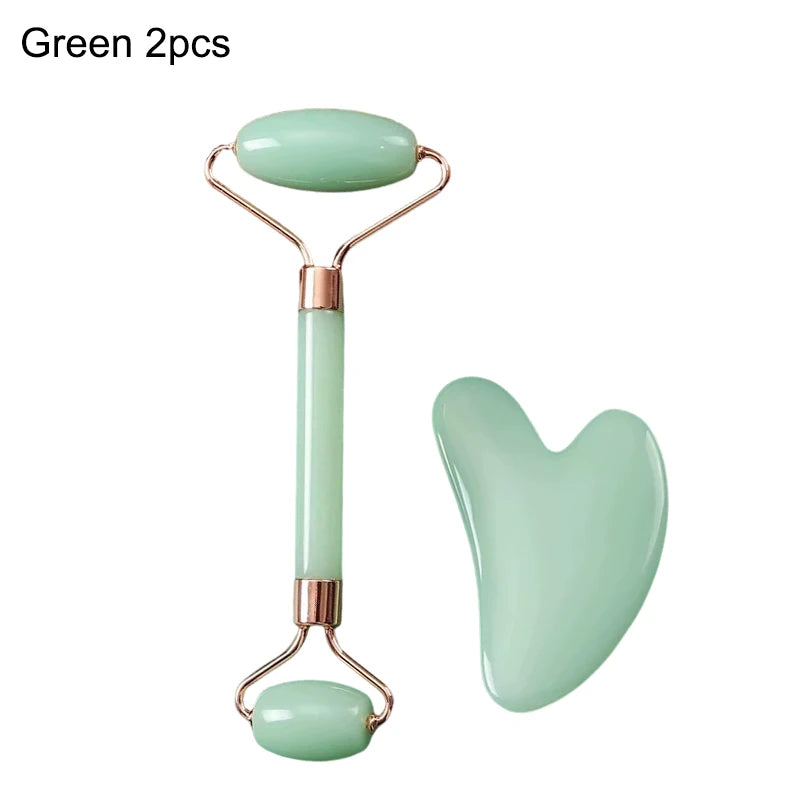 A light green jade facial roller and a heart-shaped gua sha massage stone with rose gold accents.