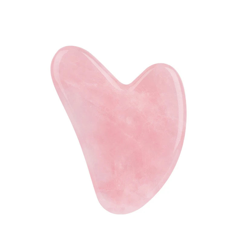 Heart-shaped pink rose quartz gua sha tool for facial massage and skin scraping.