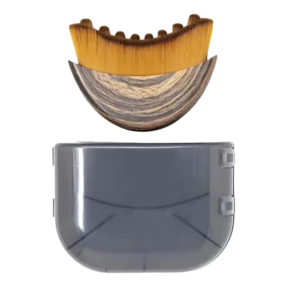 Curved facial brush with soft gold bristles and a wood-grain handle, shown above its translucent grey protective cover.