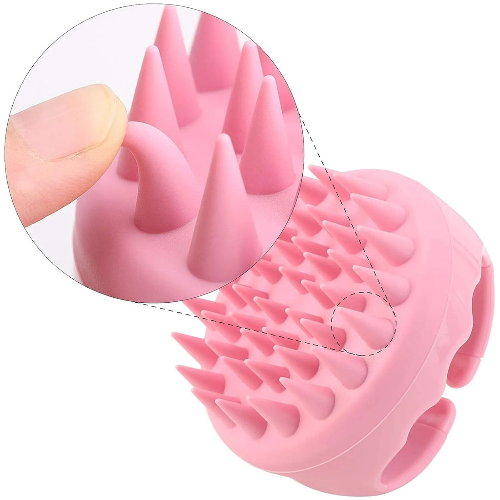 Pink silicone scalp massager brush with flexible, conical bristles, showing a close-up of a finger bending a bristle.