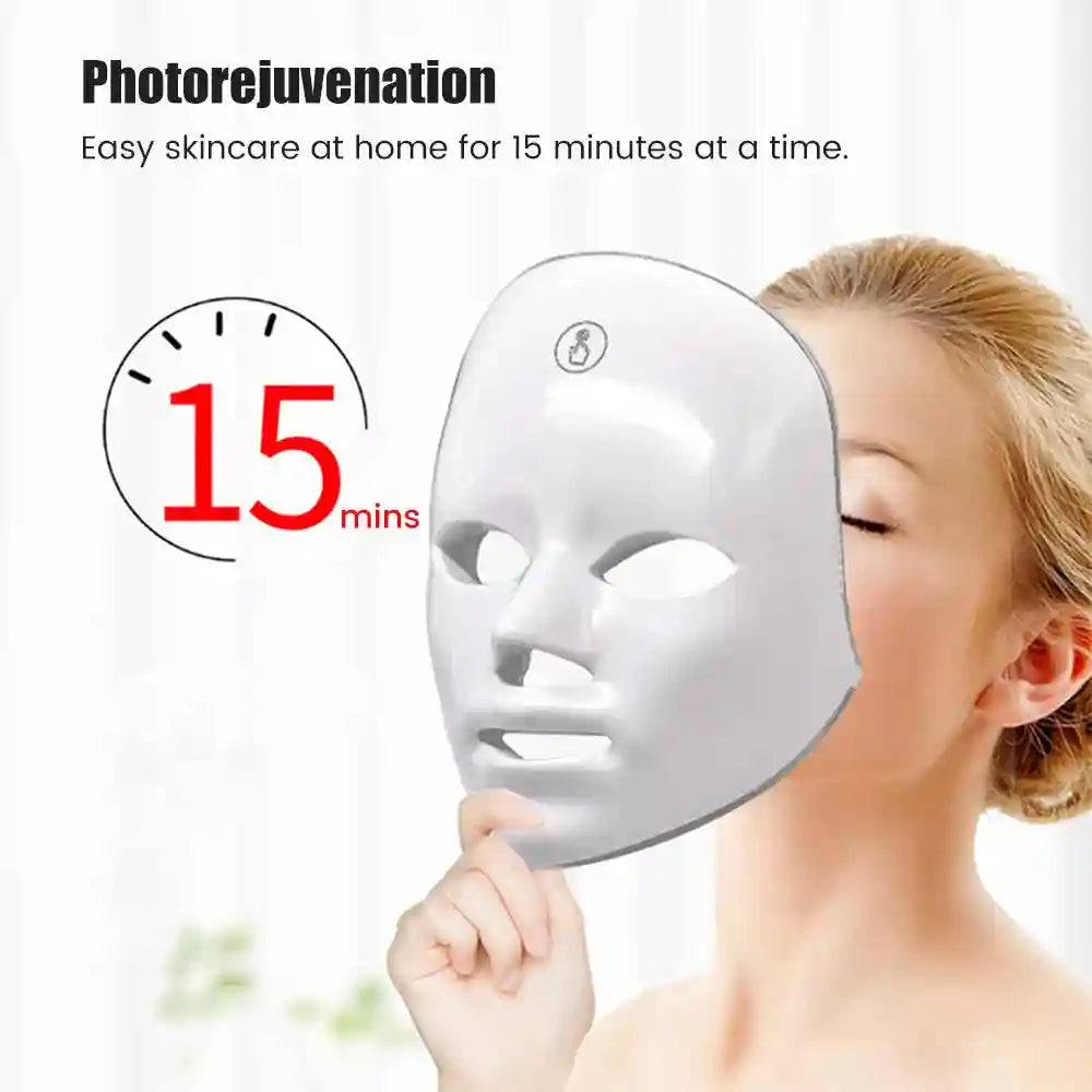 A woman holds a smooth, white, contoured LED facial mask up to her face next to a "15 mins" timer graphic.